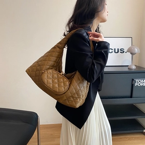 Brown quilted Hobo shoulder bag with detachable mini purse shown in lifestyle context