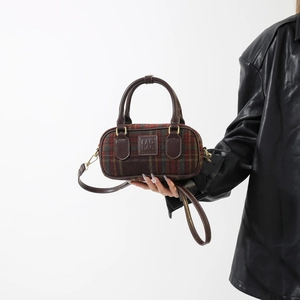 Dettaglio borsa vintage in lana scozzese con finiture in pelle marrone e logo FAD BAG