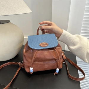 Mini sac à dos en simili cuir marron avec rabat en jean bleu et étiquette mode
