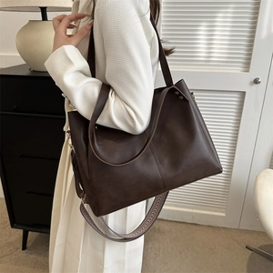 Detailed shot of dark brown PU leather tote bag with vintage patterned wide strap