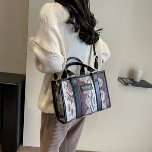 Chic tote bag with snakeskin pattern and TOTE BAG label shown on a model's shoulder