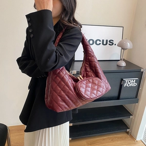Close-up of wine red quilted hobo bag featuring fine stitching and a small round coin purse