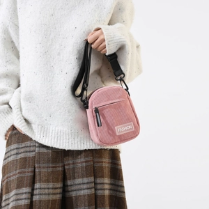 Detail of pink corduroy shoulder bag showing texture and trendy fashion patch