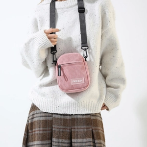 Detailed view of pink corduroy texture and Fashion label on the small crossbody bag
