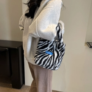 Detail of plush zebra print faux fur handbag with blue Next Wave Culture woven label