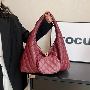 Detail of wine red quilted PU leather tote bag with a small matching round coin purse