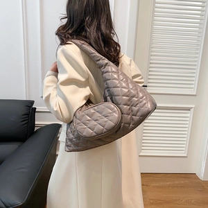 Detail of grey quilted shoulder bag with wide strap and round detachable coin purse