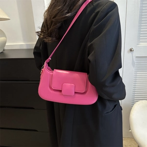 Detail of rose pink PU leather baguette bag with magnetic flap closure and slim shoulder strap