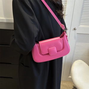 Magenta PU leather shoulder bag with adjustable strap worn over a black blazer