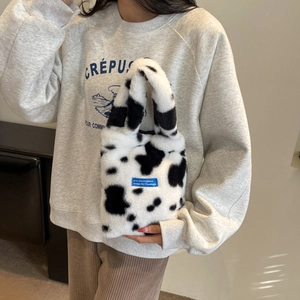 Winter faux fur handbag featuring black and white cow pattern and blue label