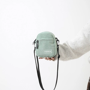 Minimalist mint green corduroy crossbody bag with adjustable strap and fashion label