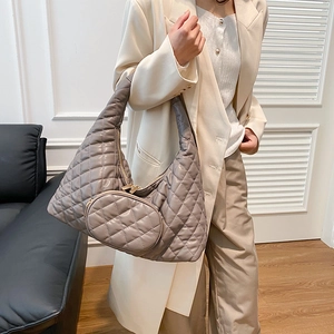 Gray quilted hobo bag with round coin purse detail shown on a chic female model