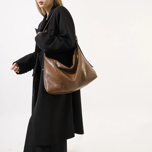 Brown hobo bag in glossy oil wax PU leather with natural folds and wide strap