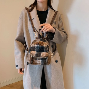 Dettaglio mini zaino in lana a quadri con spalline in pelle marrone e zip dorate