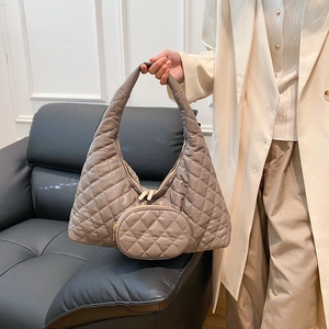Detail of taupe quilted hobo bag featuring gold dual zippers and a matching mini coin purse