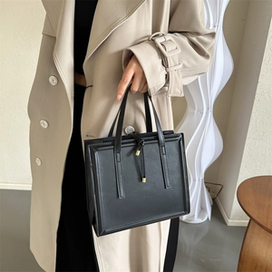 Minimalist black PU leather rectangular handbag styled with a classic beige trench coat
