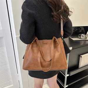 Brown PU leather tote bag featuring a decorative geometric strap and embossed detail