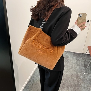 Close-up of brown plush tote bag showing soft faux fur texture and chain strap detail