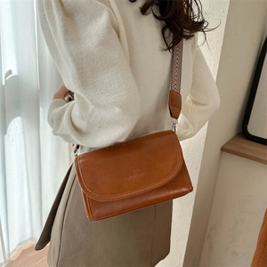 Caramel brown PU leather crossbody bag with patterned wide strap and embossed logo