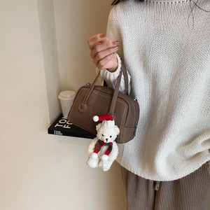 Brown Boston handbag detail featuring a cute white teddy bear charm with a red Christmas hat