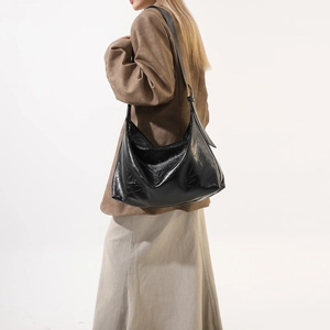 Glossy black hobo shoulder bag with leather texture and golden metal buckle detail
