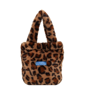 Minimalist faux fur handbag with leopard print and a woven blue label on white background
