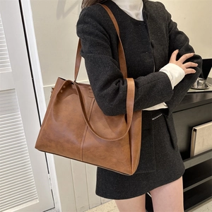 Close-up of brown PU leather tote bag featuring detailed stitching and vintage texture