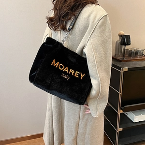 Detail of black faux fur shoulder bag with gold MOAREY italy embroidery and chain strap