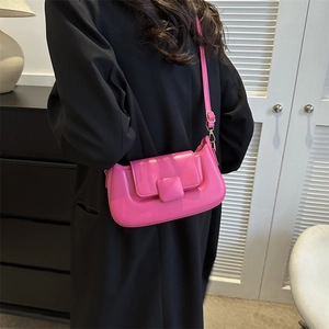 Fashionable rose red PU leather crossbody bag worn by a model in a modern home setting