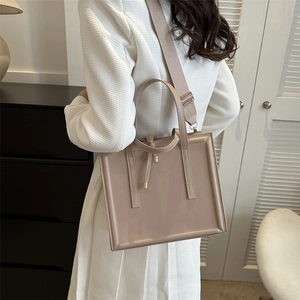 Close-up of khaki PU leather tote bag featuring a stylish wide shoulder strap and tied detail
