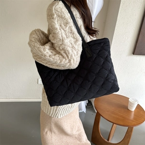 Gros plan sur le sac cabas noir matelassé montrant la texture et la grande capacité