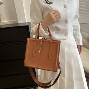 Detail of a structured brown PU leather square handbag featuring a drawstring closure
