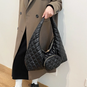 Detail of black quilted hobo bag in glossy leather with round coin purse and gold zipper