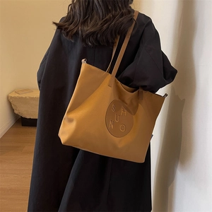 Detail of minimalist tote bag with SHUNO embossed leather patch and canvas texture