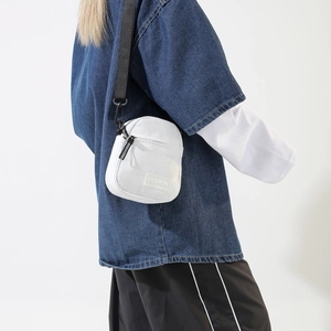 Detailed side view of white corduroy crossbody bag worn by a model for size and scale