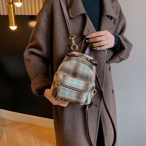 Dettaglio mini borsa a quadri in lana con cinturini in pelle marrone e fiocco dorato