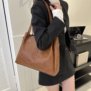 Classic dark brown PU leather tote bag worn by a model in a professional office setting