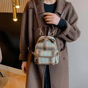 Dettaglio mini borsa a tracolla in lana a quadri con cinturini in pelle marrone e zip dorate