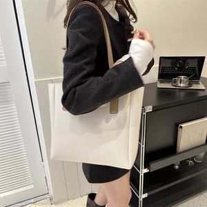 Minimalist beige PU leather tote bag shown in a professional office setting for work