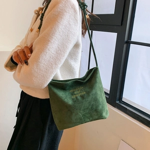 Detail of dark green suede crossbody bag featuring onwards and upwards embroidery