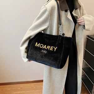 Chic black plush tote bag with yellow embroidery on soft faux fur, styled with chain strap