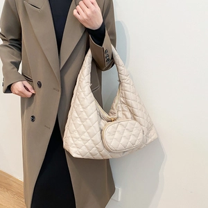 Close-up of a beige quilted hobo bag with a matching small round coin purse charm
