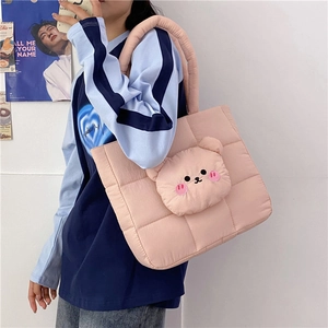 Detail of pink quilted nylon tote bag featuring a 3D plush bear and soft padded handles