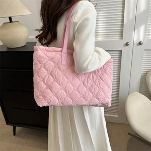 Vue détaillée d'un grand sac cabas rose matelassé dans un décor intérieur moderne