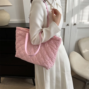 Détail du sac fourre-tout matelassé rose avec motif en losanges et texture en nylon