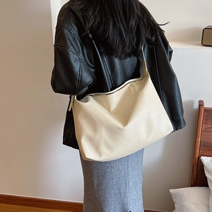 Chic cream-colored shoulder bag featuring lychee texture on model's back for daily style