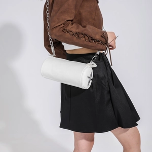 Detail of white cylinder crossbody bag with silver star hardware and grainy texture leather