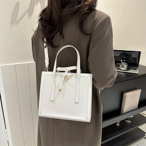 Chic white PU leather handbag with wide shoulder strap shown in a modern interior setting