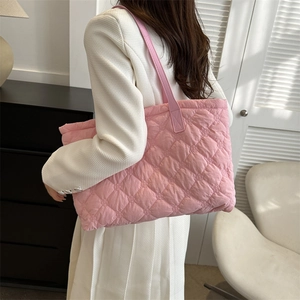 Gros plan sur le sac fourre-tout matelassé rose avec tissu doux et longues poignées