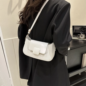 Close-up of a white minimalist PU leather underarm bag with a square buckle on a model